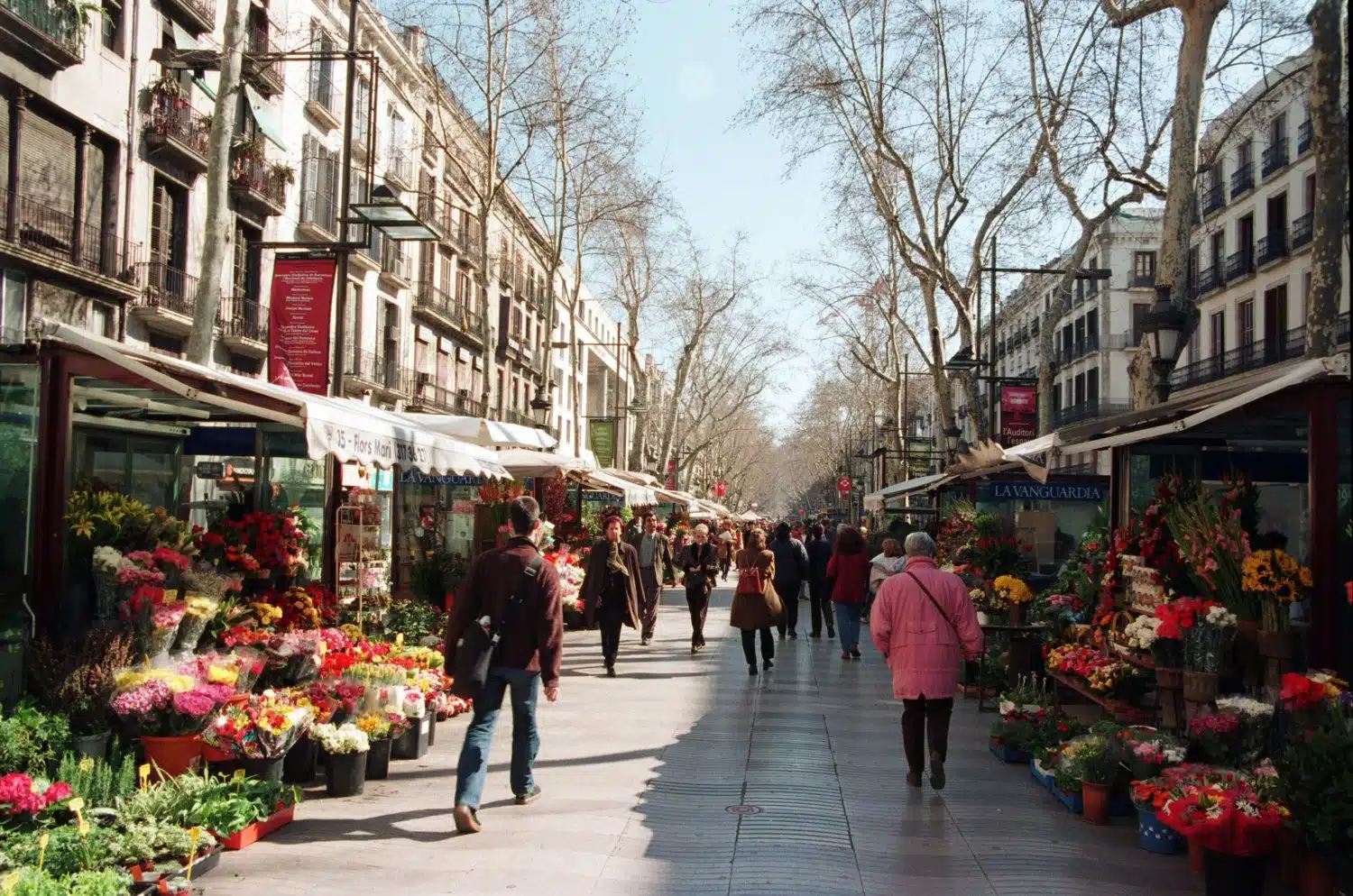 La Rambla de Barcelona, con gente paseando, comercios y ambiente urbano.